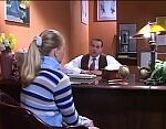 Blonde teen sitting at counselors desk discussing grades.